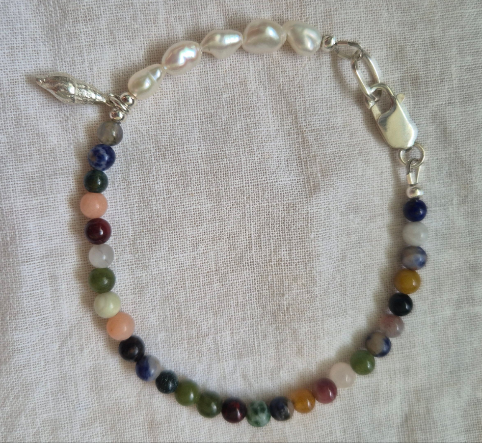 Spiral shell charm on a gemstone and keish pearl bracelet